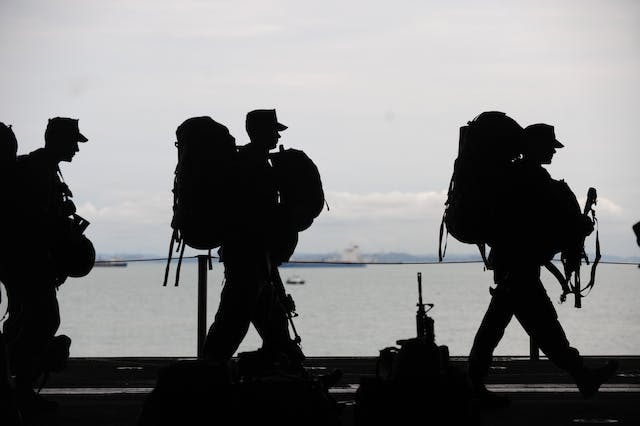A silhouette of a person carrying a backpack

Description automatically generated