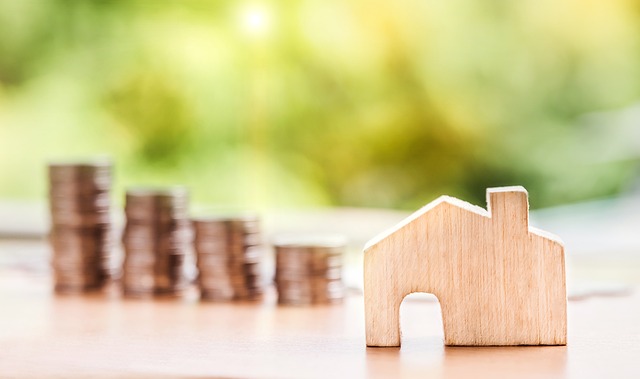 wooden house next to four piles of coins