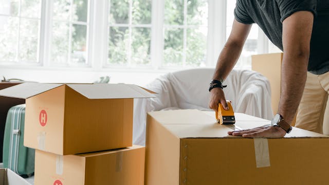 person packing up moving boxes